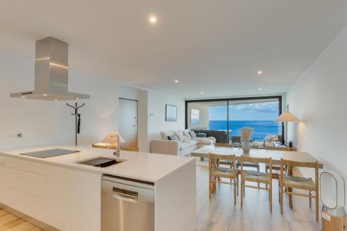 a kitchen and living room with a view of the ocean at Atlantic Heights Varandas do Atlântico by Holiday Rental Madeira in Câmara de Lobos