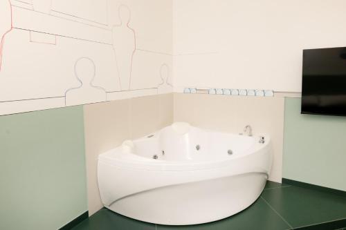 a white bathroom with a sink and a tv at O Effe Games Vatican in Rome