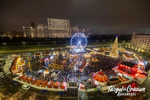 a christmas market in a city with a ferris wheel at CHIC Apartment Piata Constitutiei - near the Palace of Parliament in Bucharest