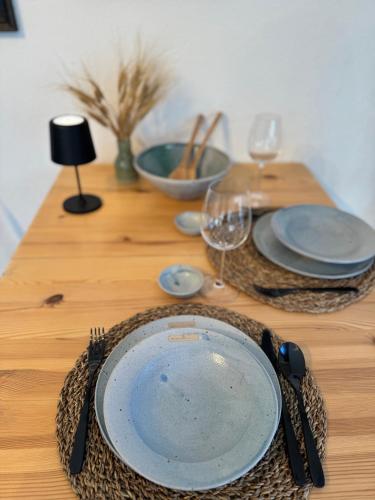 a wooden table with a plate and glasses on it at Sonnmatten Boutique Hotel & Apartments Zermatt in Zermatt