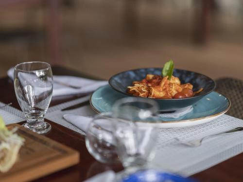a table with a plate of food and a glass at Los Vivos Beachfront Experience in Pochote