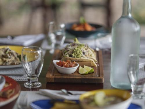 a table with a plate of food and a bottle of water at Los Vivos Beachfront Experience in Pochote