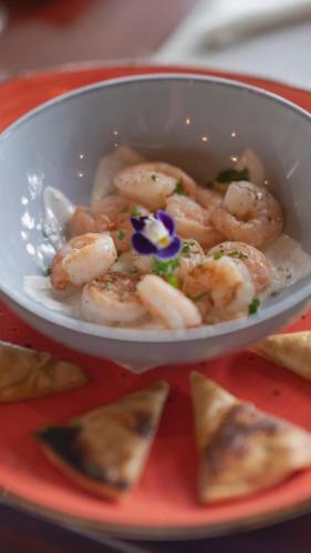 a bowl of shrimp on a red plate at Los Vivos Beachfront Experience in Pochote
