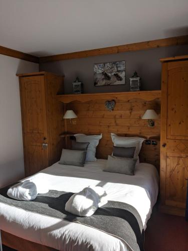 une chambre avec un grand lit avec des draps blancs dans l'établissement ARCS 1950 Prince des Cimes 2 chambres 6 pers orienté sud ouest Piscine Jacuzzi Sauna Hammam, à Arc 1950