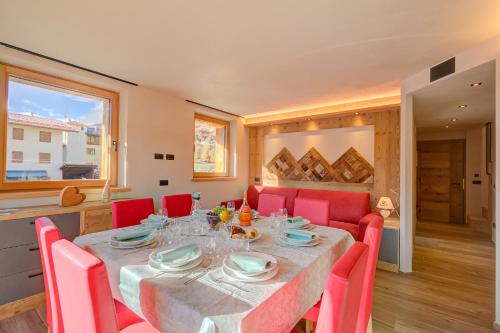 a dining room with a table and red chairs at Cuore Alpino in Livigno