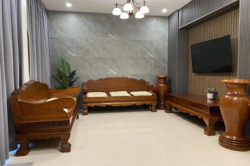 a living room with wooden furniture and a flat screen tv at Sanaepatan Home Resort - เสน่ห์ป่าตาล โฮม รีสอร์ต in San Kamphaeng