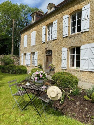 Un chapeau assis sur une table devant une maison dans l'établissement Domaine de La Lipomerie - LA PETITE MAISON, à Gâprée