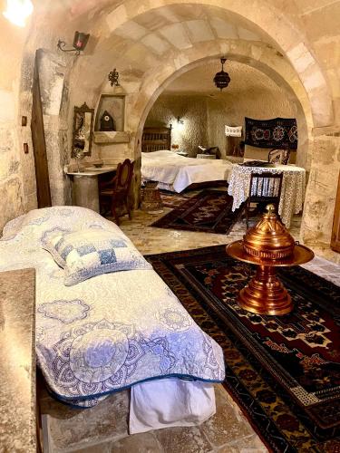 a bedroom with two beds in a stone room at Sofa Hotel in Avanos