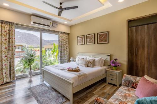 una camera da letto con un letto e una grande finestra di ELIVAAS Heaven in Hills Valora 6 BHK Pet friendly villa with Pvt Pool a Udaipur