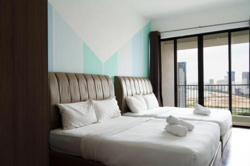 two beds with teddy bears on them in a hotel room at The Landmark Seaview Suite in Tanjong Tokong