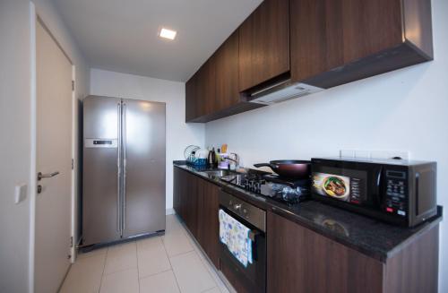 a kitchen with a microwave and a refrigerator at The Landmark Seaview Suite in Tanjong Tokong