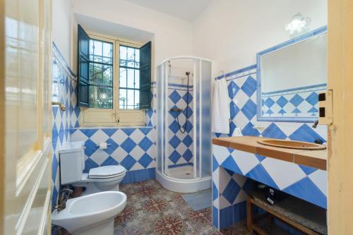 un bagno blu e bianco con un water e un lavandino di Casa rural Hacienda San Felipe a Gerena