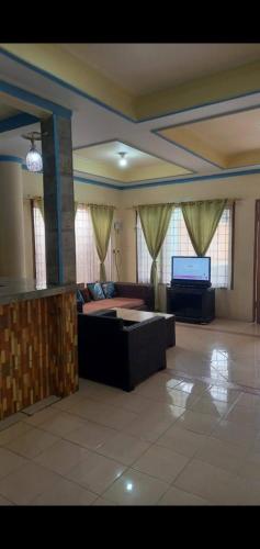 un grand salon avec un canapé et une télévision dans l'établissement Villa murah puncak, à Campaka