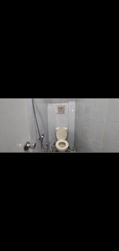 - une salle de bains avec des toilettes blanches dans une cabine dans l'établissement Villa murah puncak, à Campaka