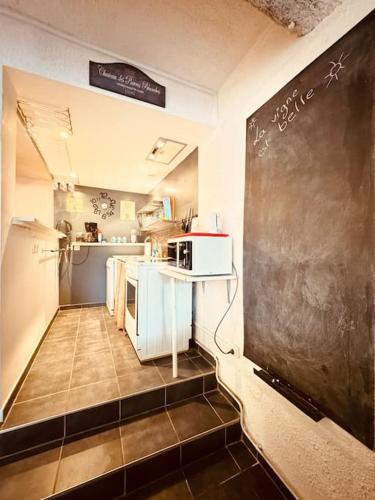 une cuisine avec un tableau noir et une cuisine avec une salle de classe dans l'établissement Maison de campagne avec piscine-jardin-wifi, à Canet d'Aude