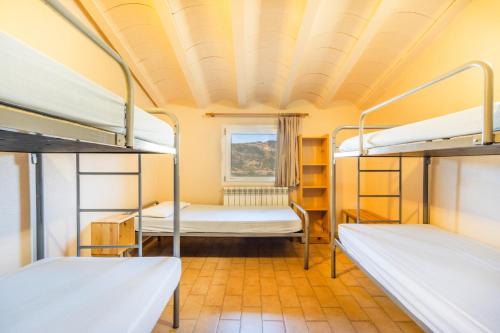 a room with two bunk beds and a window at Rectoria de Claverol in Claverol