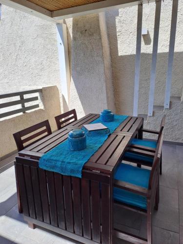 a wooden table with chairs and a blue table cloth at Appartamento vista mare in Santa Teresa Gallura