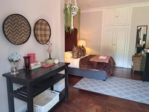 a bedroom with a bed and a table with a table sidx sidx sidx at Taunton Manor in Pietermaritzburg