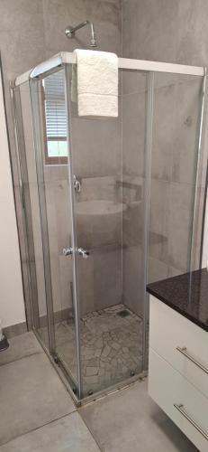 a shower with a glass door in a bathroom at De Rust Karoo Cottages in De Rust
