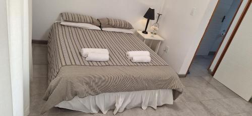 a bed with two towels on it in a room at De Rust Karoo Cottages in De Rust