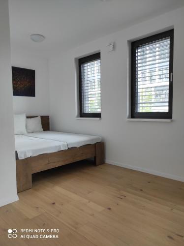 Cette chambre blanche dispose d'un lit et de deux fenêtres. dans l'établissement Blumental, à Staré Mesto