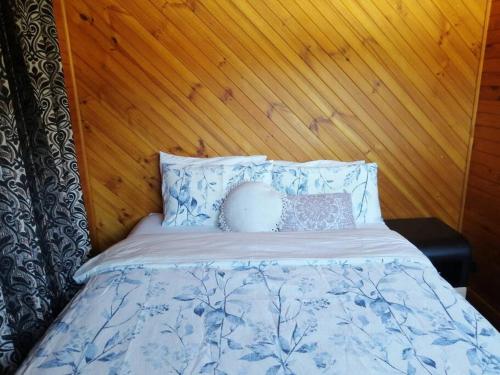 a bed with a wooden head board and pillows at Stunning Holiday Home in Dunwich Stradbroke Island in Dunwich