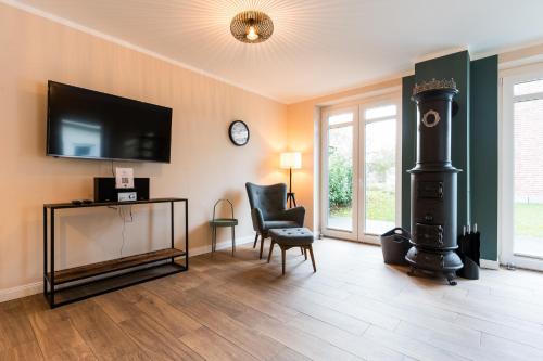 ein Wohnzimmer mit einem schwarzen Herd und einem Stuhl in der Unterkunft Schusterkate - [#96108] in Staberdorf