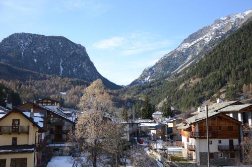 a small town in the mountains with snow at Hostdomus - Florence Apartments in Cesana Torinese