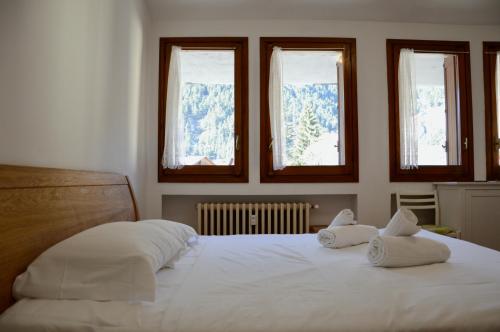 a bedroom with a bed with two pillows on it at Hostdomus - Florence Apartments in Cesana Torinese