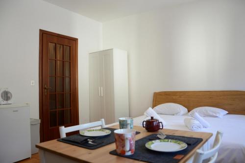 a bedroom with a bed and a table with plates of food at Hostdomus - Florence Apartments in Cesana Torinese