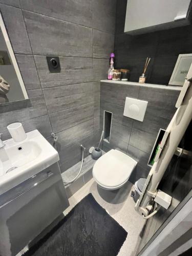 une salle de bain avec des toilettes blanches et un lavabo dans l'établissement Le Saint-Brice de Paris, à Saint-Brice-sous-Forêt