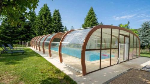 - une piscine avec une baie vitrée à côté de la piscine dans l'établissement Cabane 3 étoiles - Piscine - eececg, à Chamberet