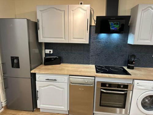 a kitchen with white cabinets and a stainless steel refrigerator at Zen Mayar House Toulouse centre in Toulouse