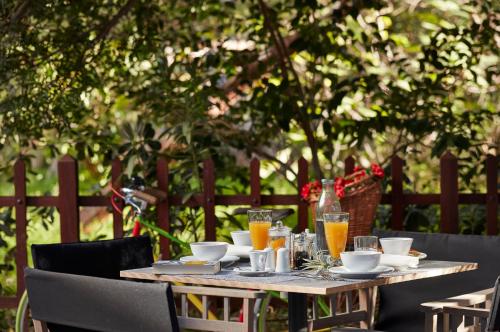 una mesa de madera con vasos de zumo de naranja. en The Gardens Gallery Hotel en Xylokastro