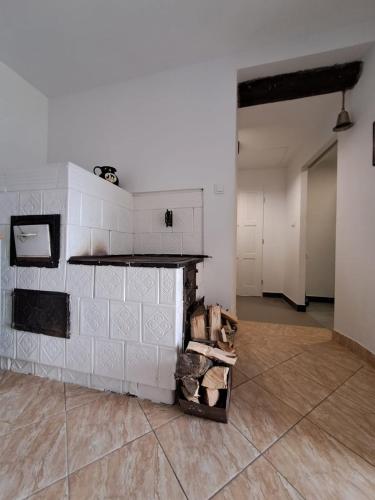 a room with a white wall and a fireplace at Górska Otulina in Wilkowisko