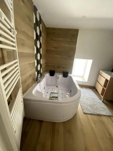 Cette chambre comprend une salle de bains pourvue d'une grande baignoire. dans l'établissement Maison de location - Les 4 Saisons, à Saint-Denis-sur-Sarthon