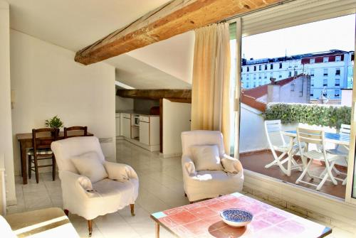 un salon avec deux chaises et une grande fenêtre dans l'établissement Le Napoléon 3P SAM1437, à Cannes