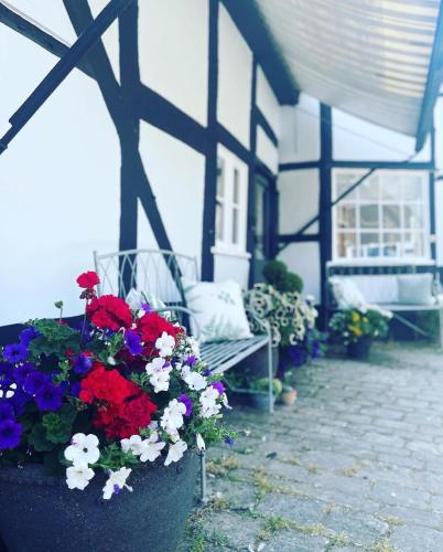 a porch with a bench and flowers in front of a building at Humbug Cottage in Much Wenlock