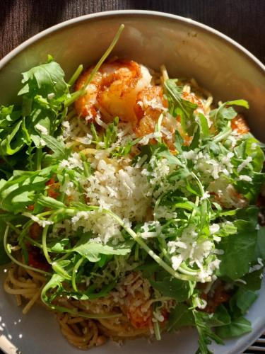 a bowl of food with a salad on top of pasta at La Cour de Grandmenil in Manhay
