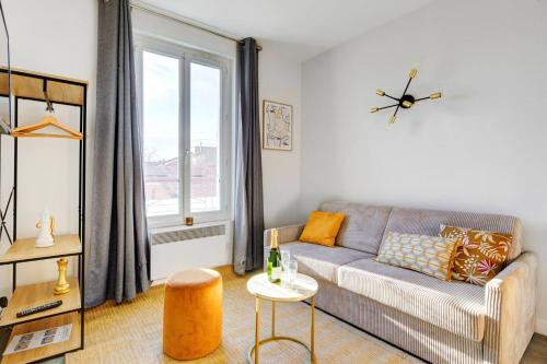 un salon avec un canapé et une fenêtre dans l'établissement Bluestay 139 - Charming apartment, à Bagnolet