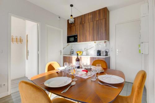 une salle à manger avec une table et des chaises en bois dans l'établissement Bluestay 139 - Charming apartment, à Bagnolet