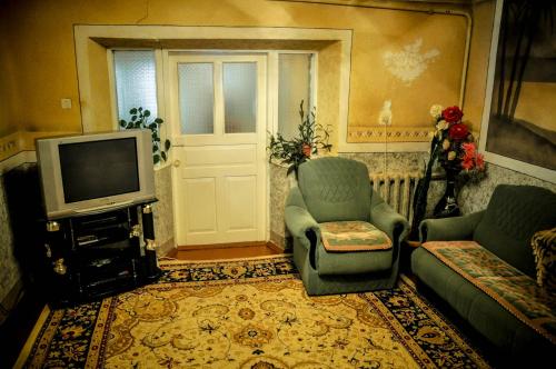 a living room with a tv and chairs and a door at Guesthouse Kishimzhan in Talas