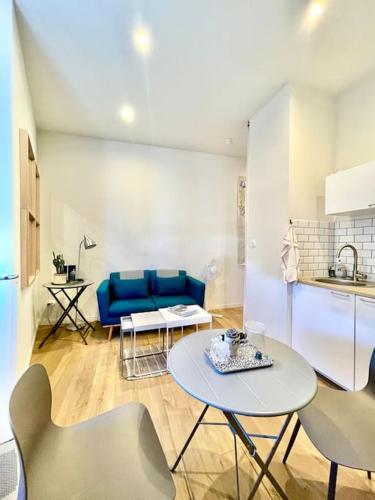 un salon avec une table et un canapé bleu dans l'établissement Le petit Musée À 2 pas des Arènes, à Nîmes