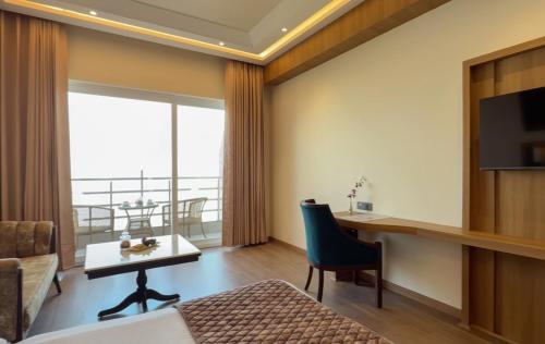 a hotel room with a bed and a desk and a television at Regenta Place Dalhousie at Mall Road in Dalhousie