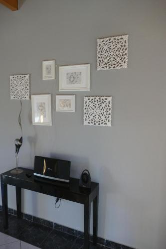 a table with a laptop on a white wall with pictures at Quartier 10 HA10 in Sögel