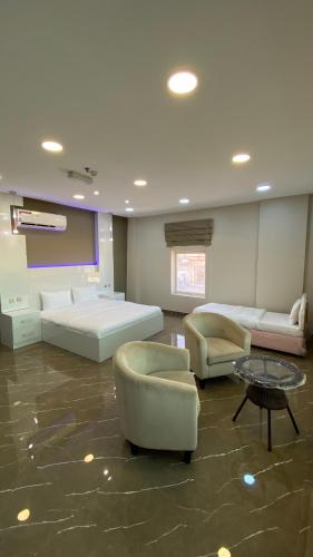 a large room with two beds and chairs and a table at Marina in Sohar