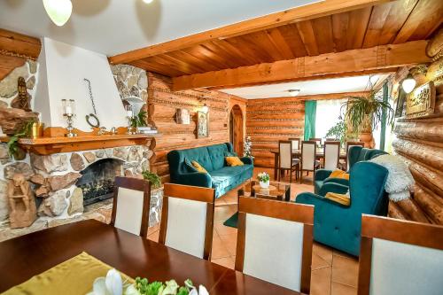 a living room with a stone fireplace and blue furniture at Marysieńka Pokoje Hrube Wyżne 12A in Zakopane