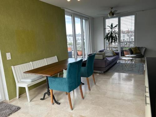 a living room with a table and chairs and a couch at Traumhafte Attikawohnung in Wallisellen