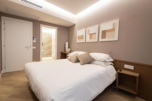 a bedroom with a large bed with white sheets at Nineteen House in Frascati