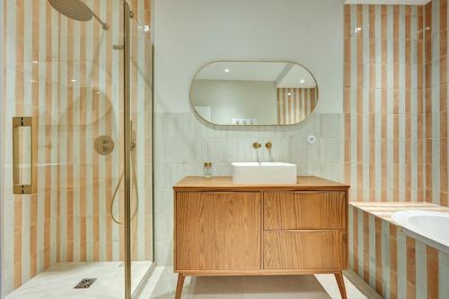 une salle de bain avec un lavabo et une douche avec un miroir dans l'établissement Appartement neuf de 210 m2 en centre ville avec jardin, à Aix-en-Provence